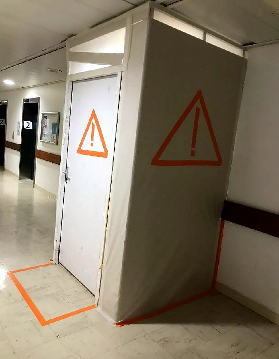 Sas de chantier étanche installé dans un couloir d'hôpital, signalisation orange
